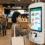 Customer using self-ordering kiosk at fast food restaurant with receipt printing